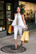 Woman walking on a sidewalk with shopping bags in front of a store named 'Seasons'.