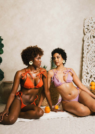2 women wearing colorful bikinis